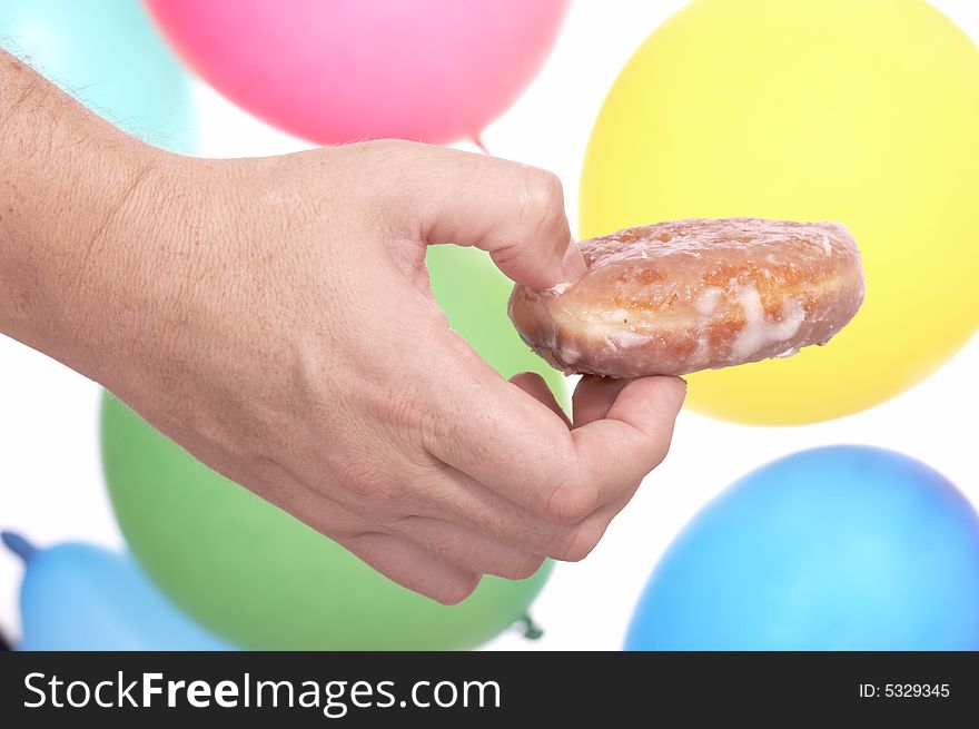 Hand holding donut with the colorful balloons