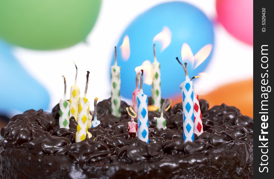 Delicious chocolate cake with the colorful candles