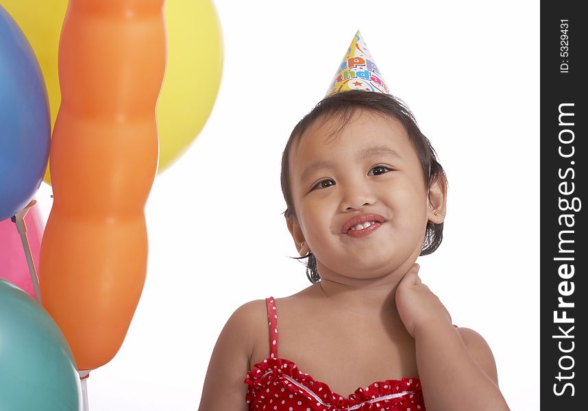 Innocent child with party hat and colorful balloons