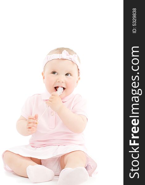 Sweet happy little girl tasting candy on stick. Over white background. Sweet happy little girl tasting candy on stick. Over white background