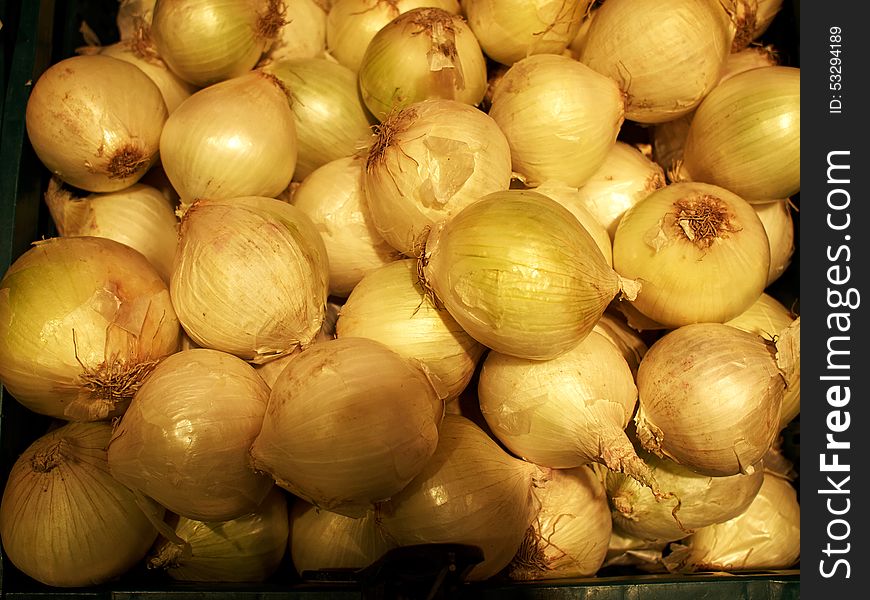 Raw ripe white onions pile on display in a market