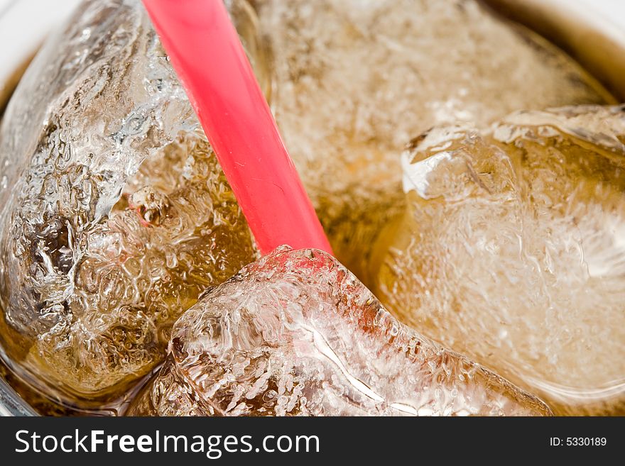 Cold fizzy cola with ice in a glass. Close up. Abstract background.