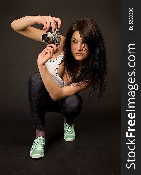 Young girl posing with retro camera isolated on black background. Young girl posing with retro camera isolated on black background