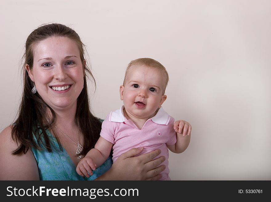 A smiling young woman with her infant daughter. A smiling young woman with her infant daughter