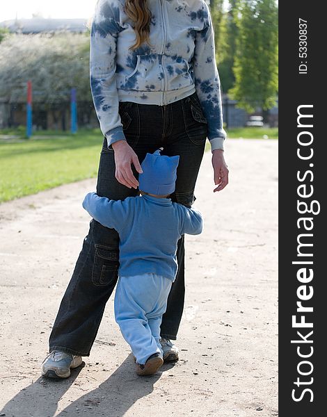 Little boy embrace mother's legs at the playground