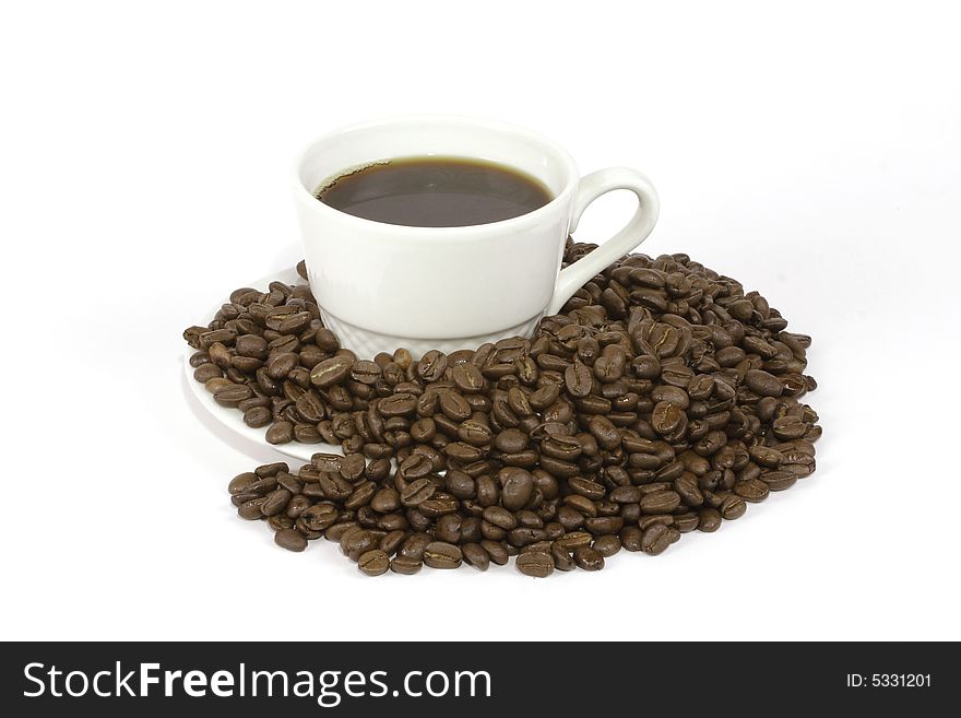 A black cup of coffee sitting on a saucer surrounded by roasted columbian coffee beans. A black cup of coffee sitting on a saucer surrounded by roasted columbian coffee beans.