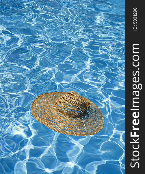 Straw hat floating in blue water