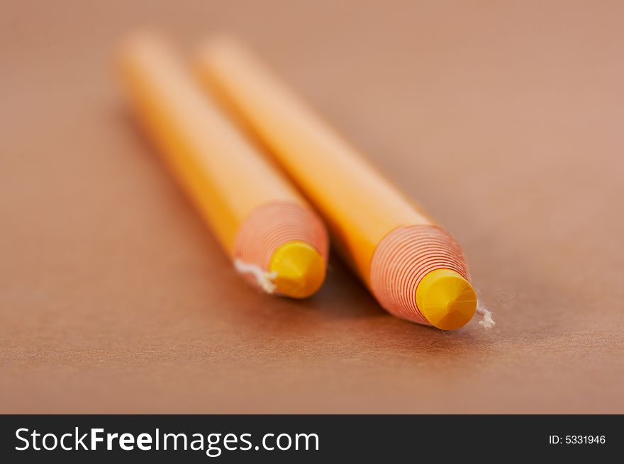 Yellow pencils on a brown paper background