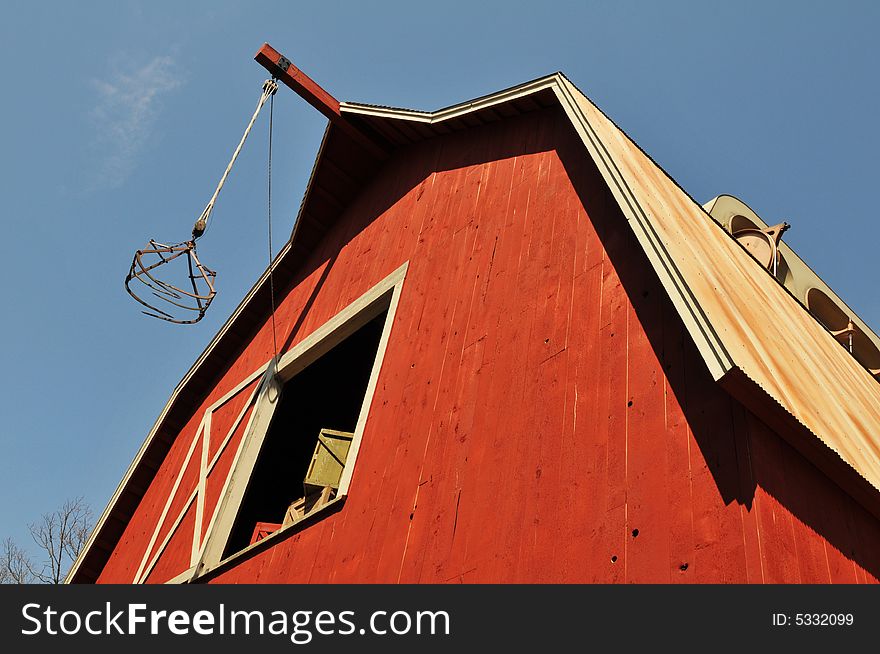 Old barn view from a low angle against a blue sky