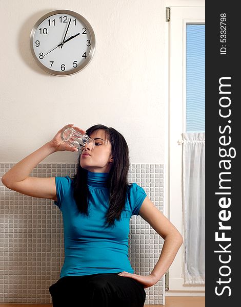 A pretty young woman lifting a glass of water. A pretty young woman lifting a glass of water