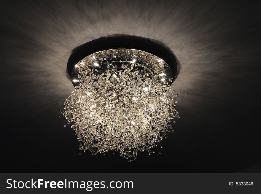 A peculiar shaped ceiling lamp looks like many stars in a bedroom. A peculiar shaped ceiling lamp looks like many stars in a bedroom.
