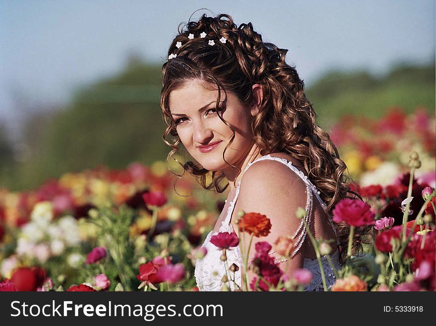 Bride sitting in flowers field