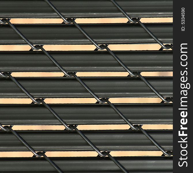 Close up view of wire fence with black slats