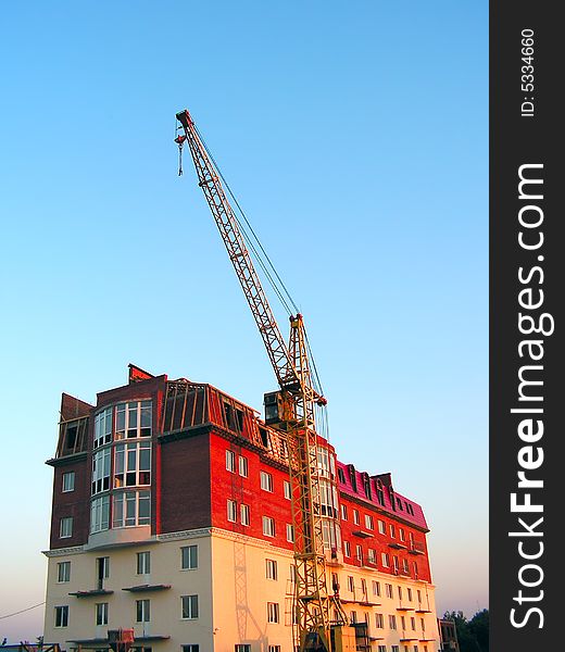 The building crane stands near a builded house