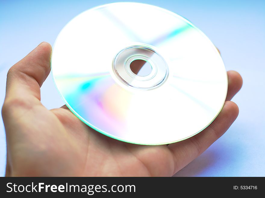 A hand handing over a CD or DVD with white background. A hand handing over a CD or DVD with white background.