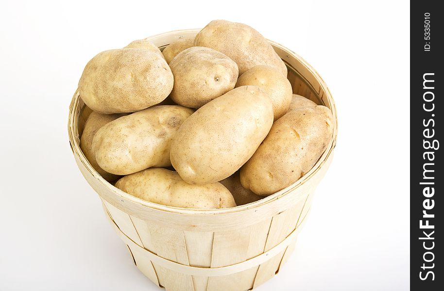 Potatoes in a woven basket on a white background. Potatoes in a woven basket on a white background