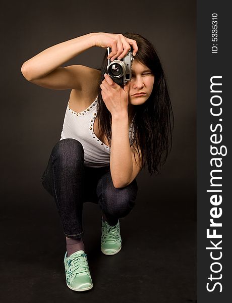 Young girl posing with old camera isolated on black background. Young girl posing with old camera isolated on black background