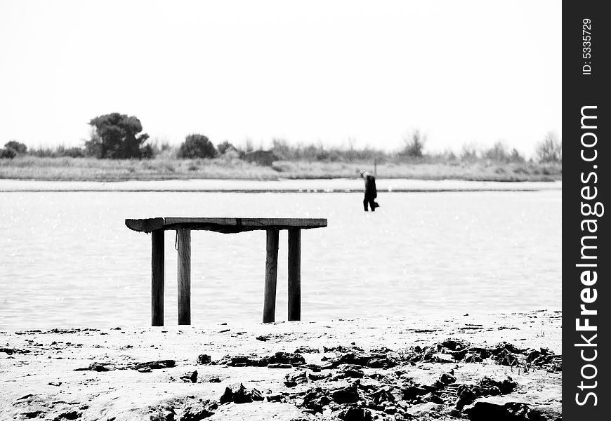 Seaside scene, man in the background, wood composition on the foreground. Seaside scene, man in the background, wood composition on the foreground