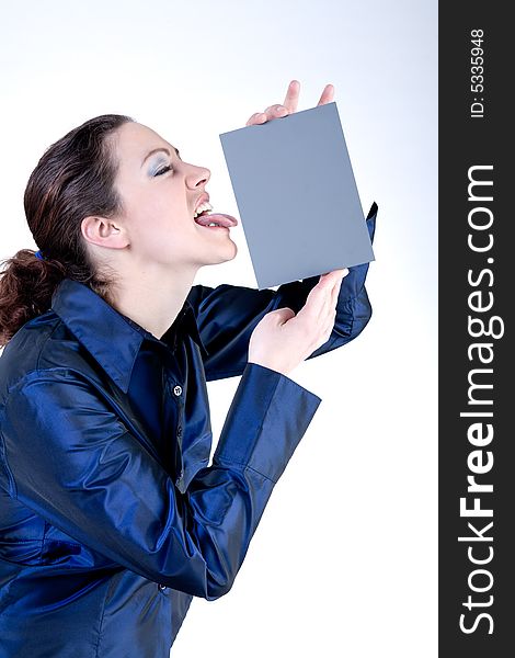 Portrait of a woman with long curly hair putting her tongue against a grey card. Portrait of a woman with long curly hair putting her tongue against a grey card