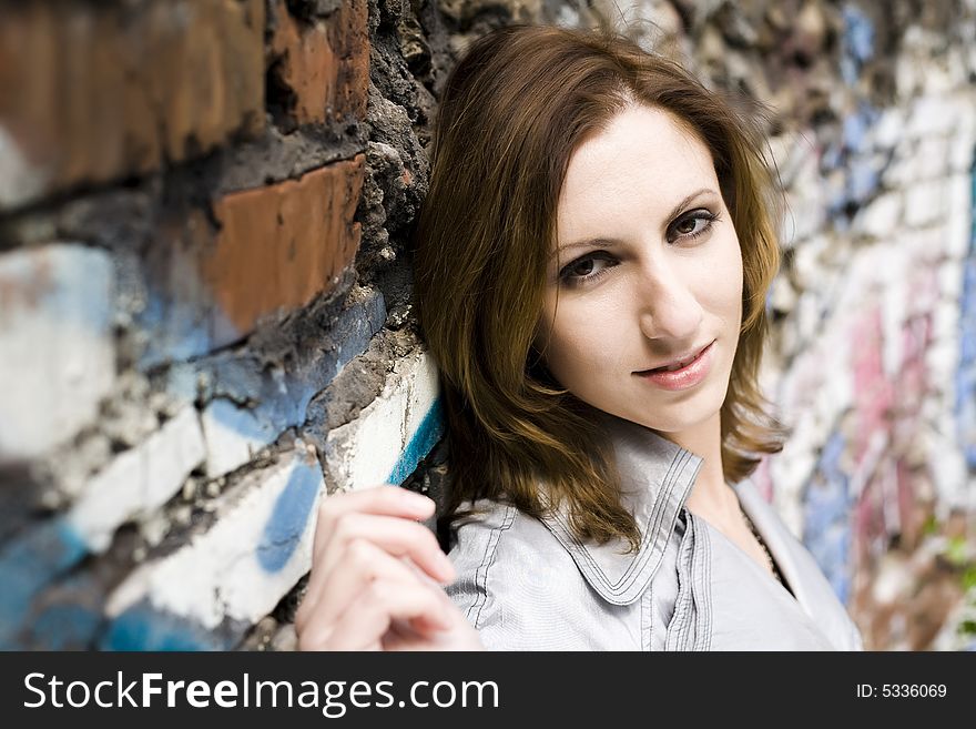 Model Woman Leaning Against A Concrete Wall