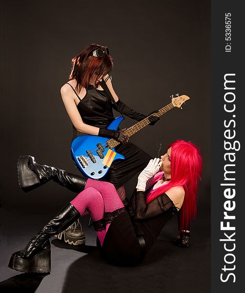 Two rock girls looking at each other isolated in studio