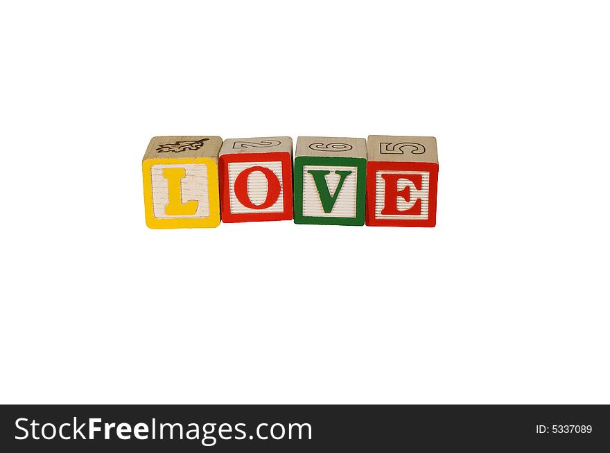 Toy wooden blocks spelling LOVE with yellow, red, and green