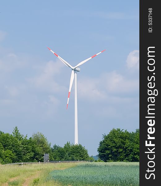 Windmill with green field and blue sky background. Windmill with green field and blue sky background