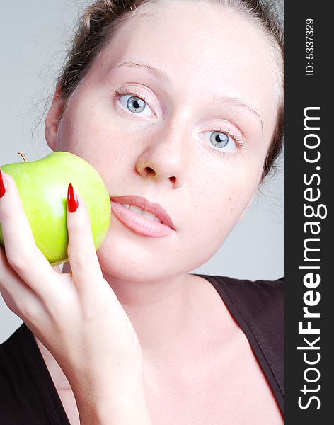 The person of the beautiful girl with a green apple in a hand and red manicure. The person of the beautiful girl with a green apple in a hand and red manicure