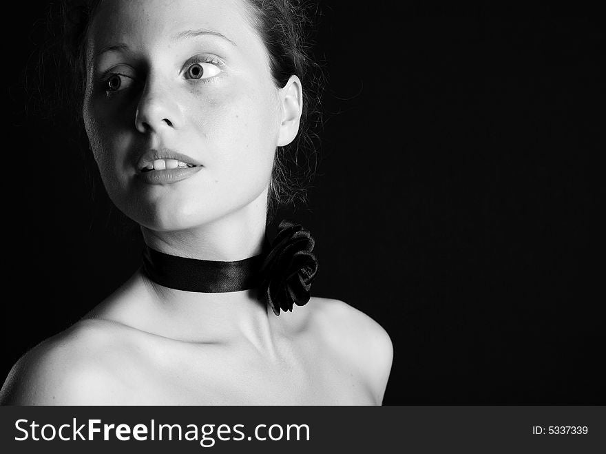 Portrait of the beautiful naked girl with an ornament on a neck on a black background. Portrait of the beautiful naked girl with an ornament on a neck on a black background