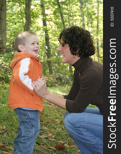 Mother and son laughing as they go for a quality walk in the woods together.