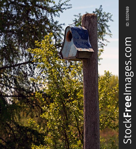 Old wooden birdhouse with rusted metal roof