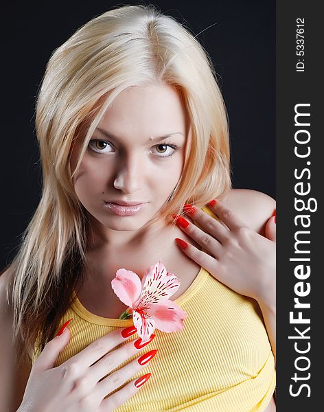 The beautiful young girl with a flower of an rosy orchid. The beautiful young girl with a flower of an rosy orchid