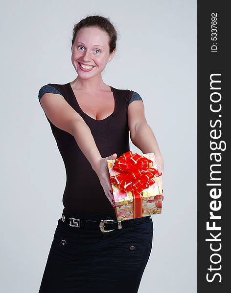 The beautiful girl in a black blouse holds a gift in hands. The beautiful girl in a black blouse holds a gift in hands