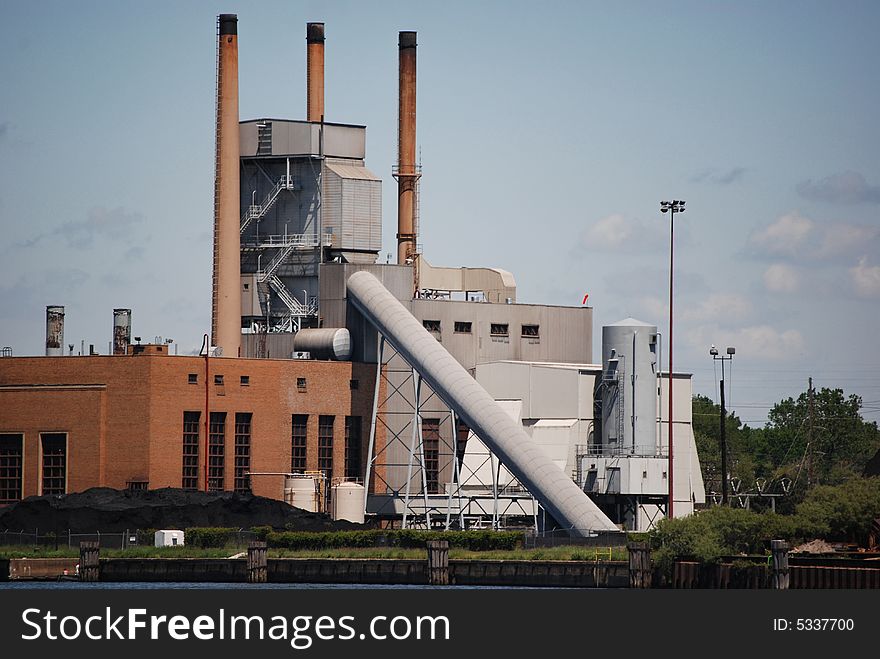 Pile of coal by a lakeshore factory. Pile of coal by a lakeshore factory.