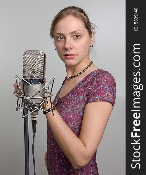 Attractive young woman with retro microphone in sound room. Attractive young woman with retro microphone in sound room