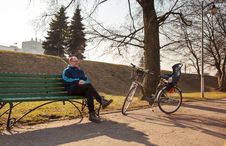 Elderly Man Sitting On A Bench Near His Bicycle In A City Park Stock Image