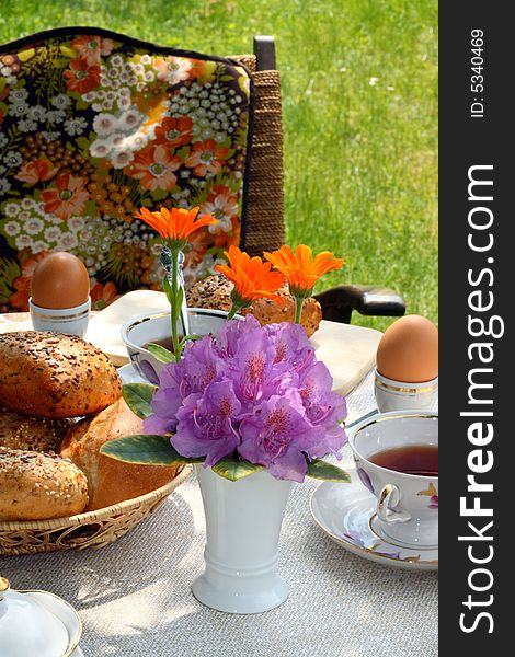 Cups of tea and simple food on a table in a garden. Cups of tea and simple food on a table in a garden.