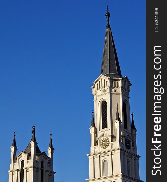A pair of ornate steeples set against a cloudless blue sky,. A pair of ornate steeples set against a cloudless blue sky,
