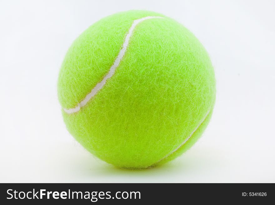 Green tennis ball laying on a white background