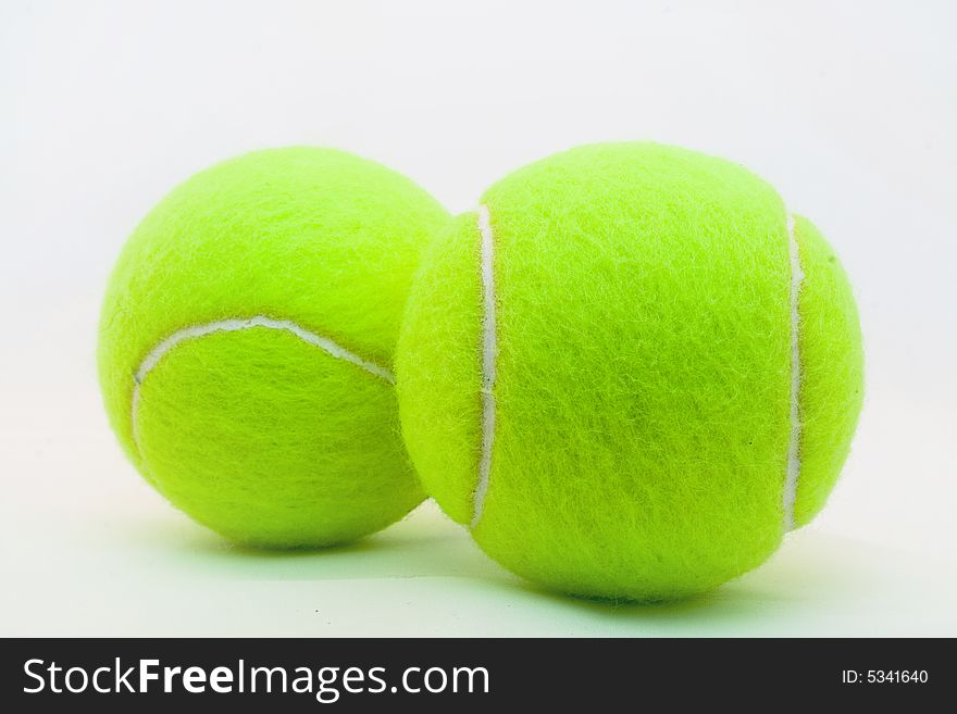 Green tennis ball laying on a white background