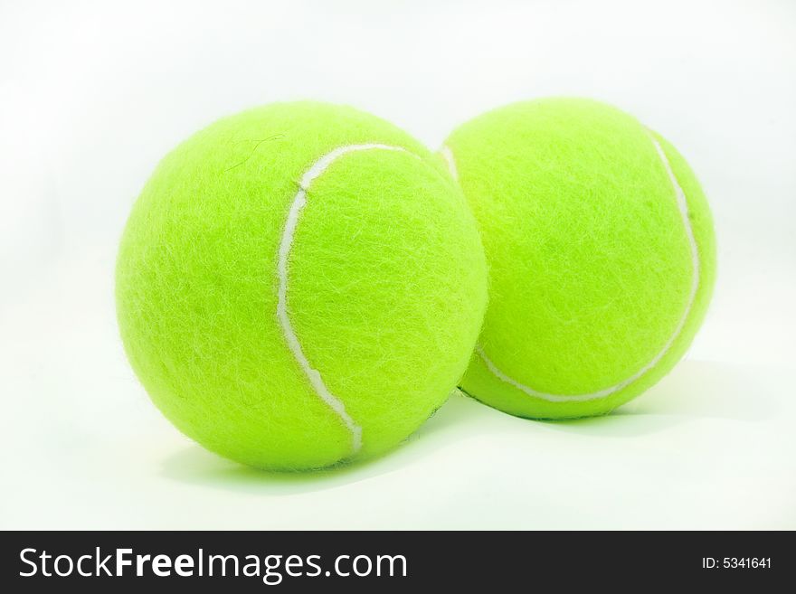 Green tennis ball laying on a white background