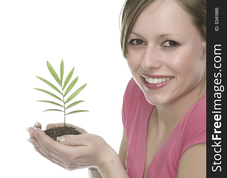 A pretty young woman holding a growing plant. A pretty young woman holding a growing plant