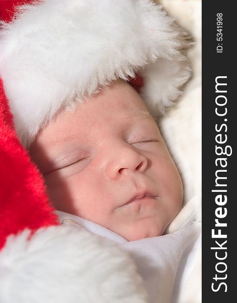 Newborn wearing a red santa hat while asleep. Newborn wearing a red santa hat while asleep