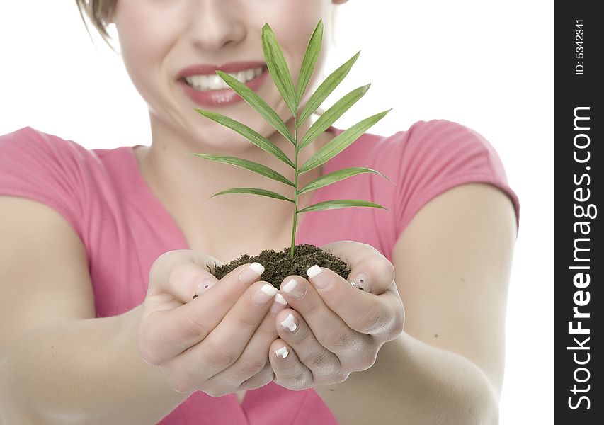 A pretty young woman holding a growing plant. A pretty young woman holding a growing plant