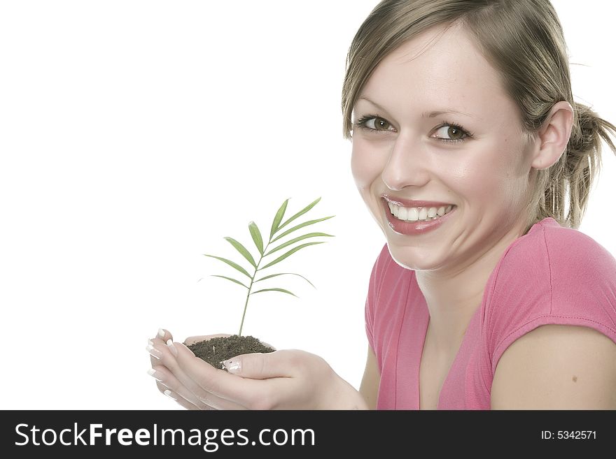 A pretty young woman holding a growing plant. A pretty young woman holding a growing plant