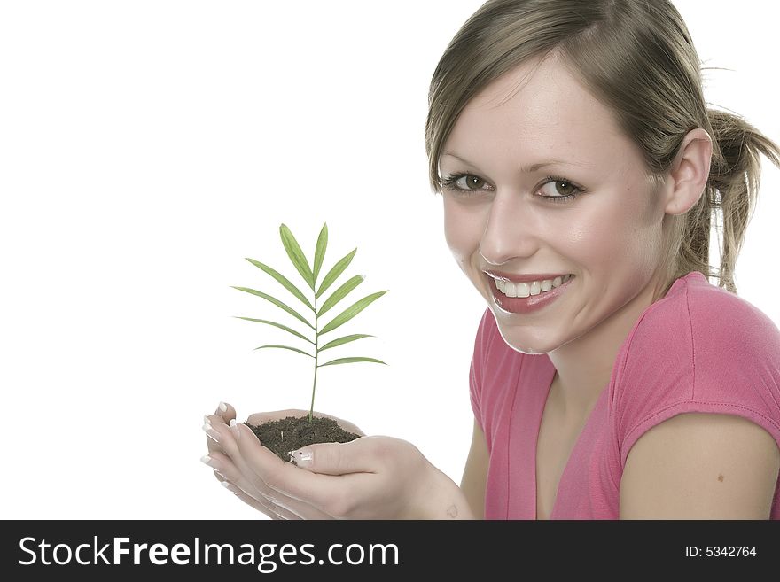 A pretty young woman holding a growing plant. A pretty young woman holding a growing plant