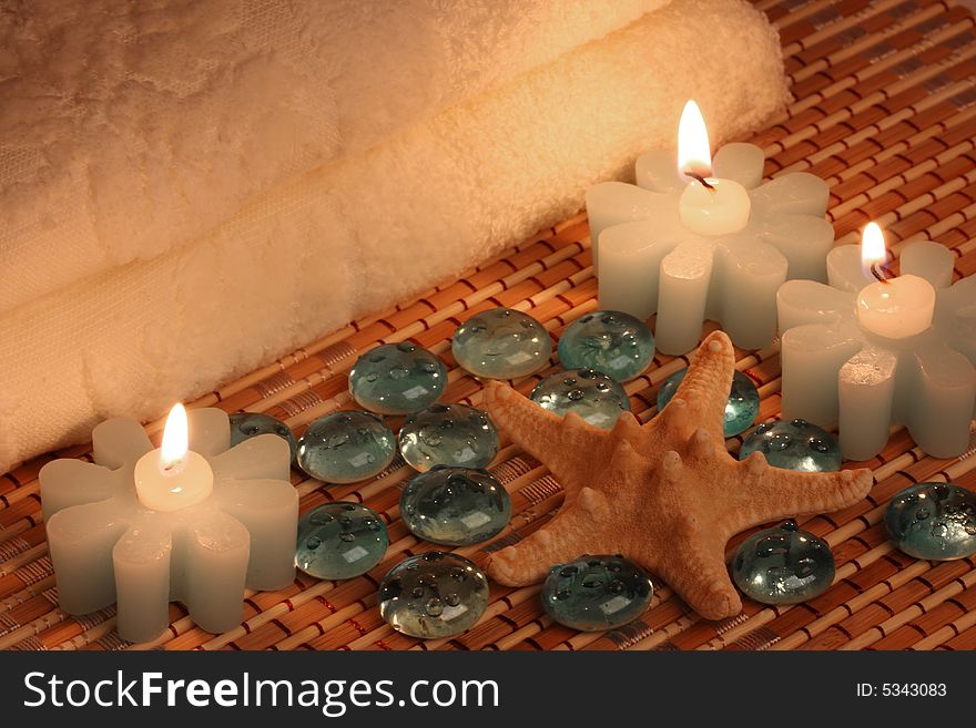 Bath towels, candles, starfish and glass pebbles. Bath towels, candles, starfish and glass pebbles