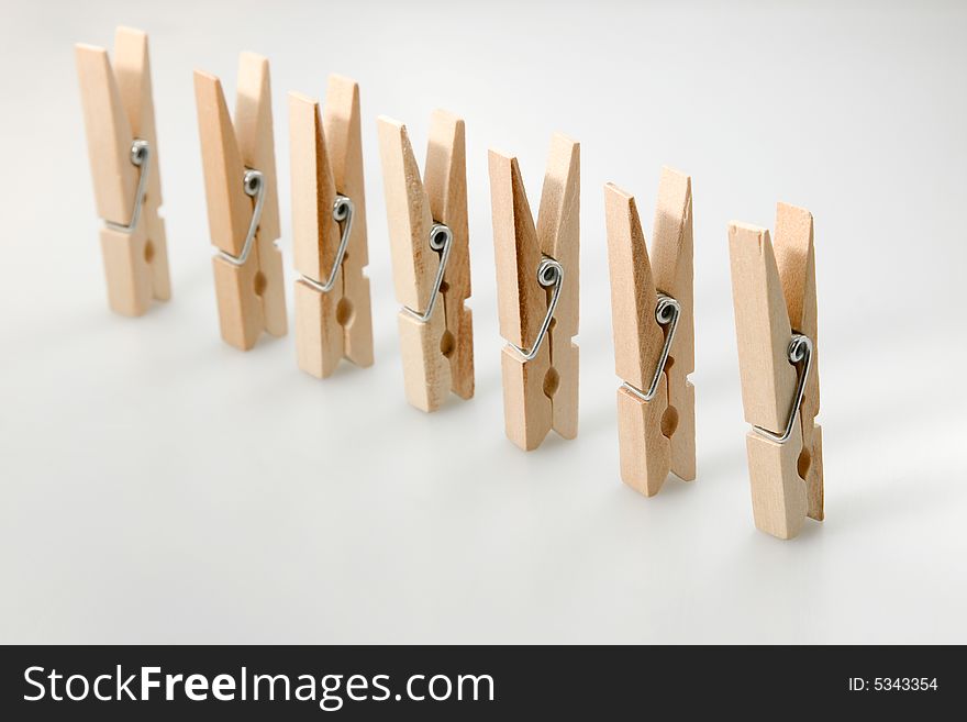 Seven isolated wooden clothespins in a row. Seven isolated wooden clothespins in a row