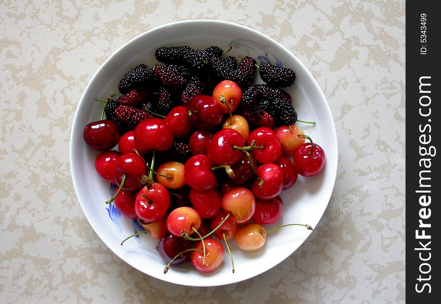 Cherry peach and blackberry are in the plate of white.