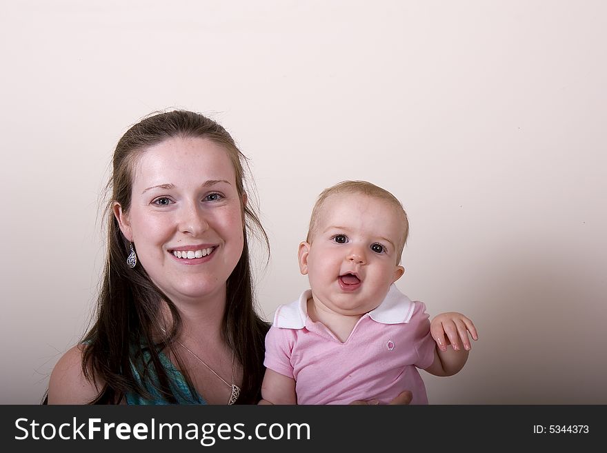 A young woman with a baby waving at the camera. A young woman with a baby waving at the camera